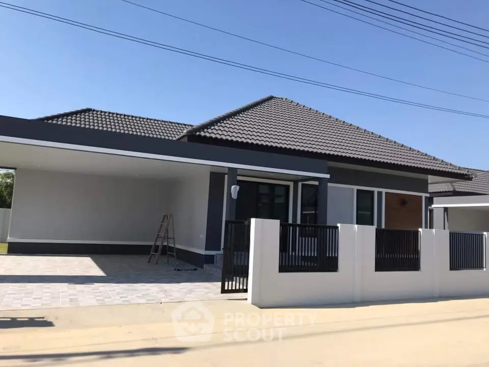 Modern single-story house with sleek design and spacious driveway in a serene neighborhood.