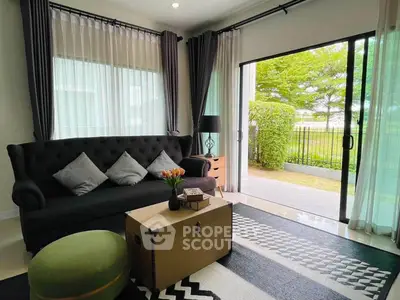 Charming living room with elegant decor and garden view, featuring a cozy sofa and stylish accents.
