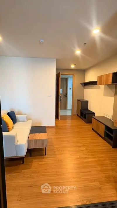 Modern living room with wooden flooring and stylish furniture in a contemporary apartment.