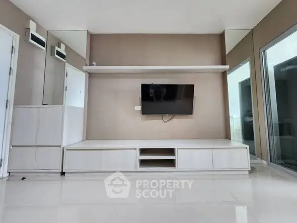 Modern living room with sleek TV unit and mirrored wall design.