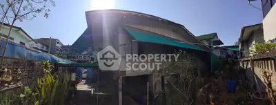 Charming residential property with lush garden and unique architectural design under clear blue sky.