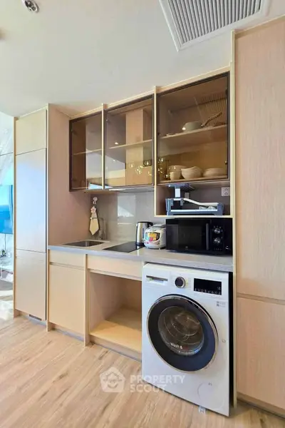 Modern kitchen with integrated appliances and washing machine in stylish cabinetry.
