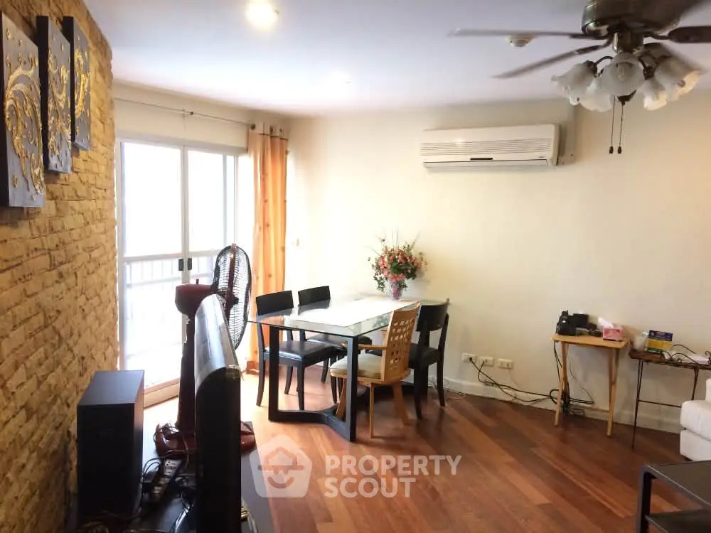 Spacious living room with wooden flooring, air conditioning, and modern decor in a stylish apartment.