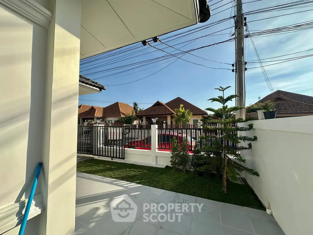 Charming residential garden with lush greenery and modern fence in a serene neighborhood.