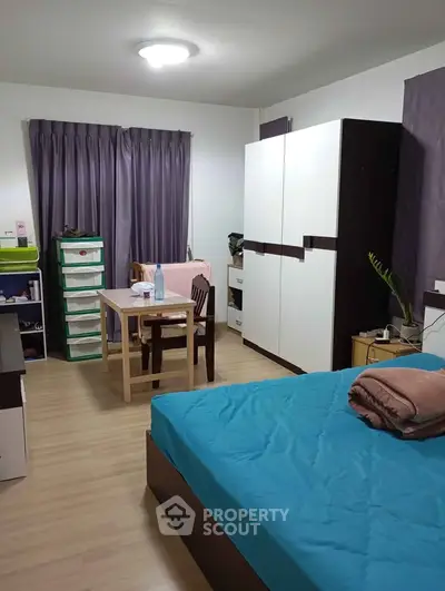 Cozy bedroom with modern furniture and natural light, perfect for comfortable living.