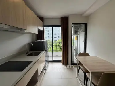 Modern kitchen with sleek cabinetry and balcony view in urban apartment