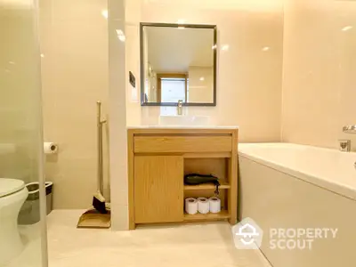 Modern bathroom with sleek design, featuring a bathtub and stylish vanity unit.