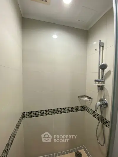 Modern bathroom shower with sleek tile design and rainfall showerhead.