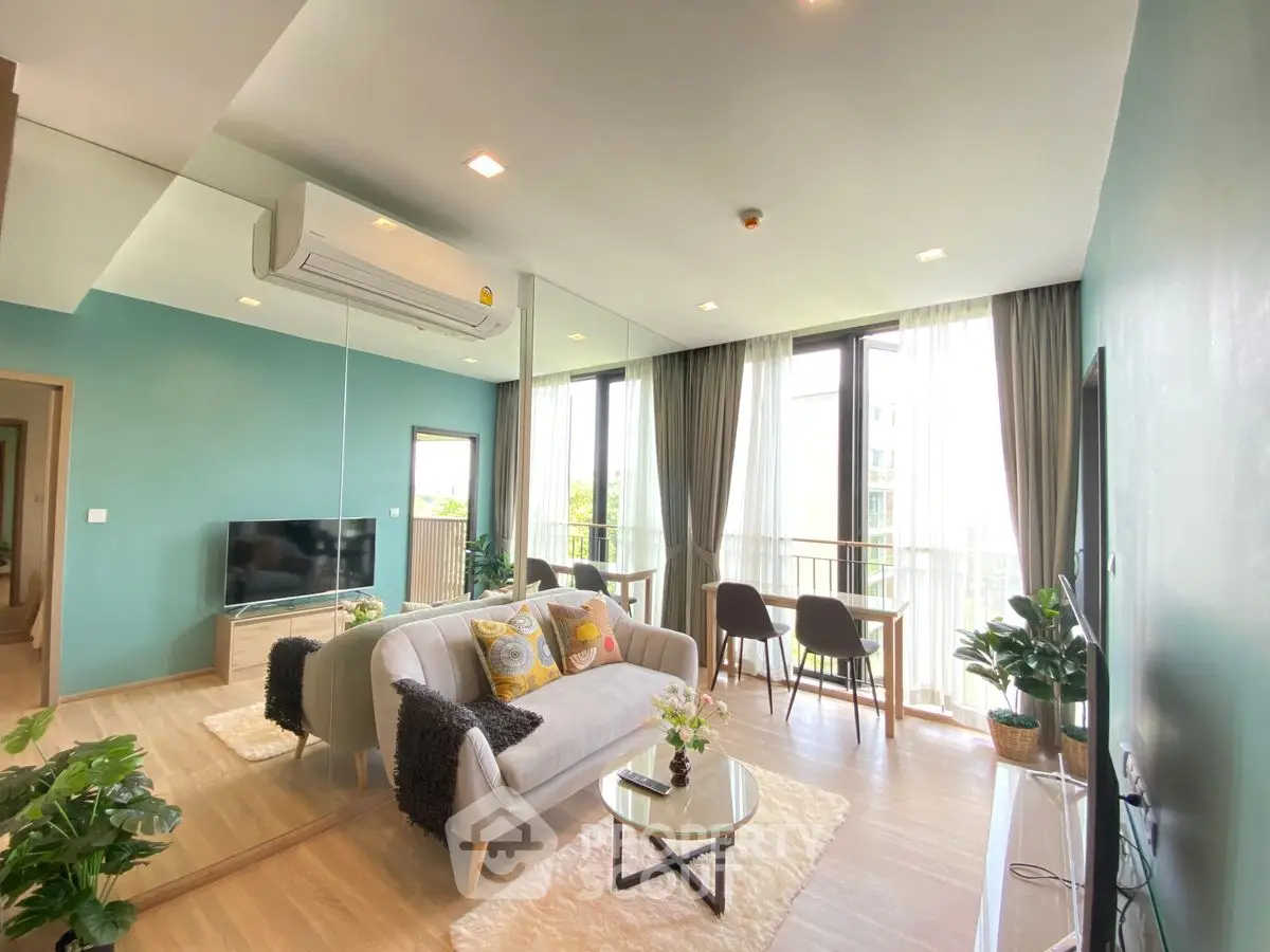 Modern living room with large windows, stylish decor, and natural light in a contemporary apartment.