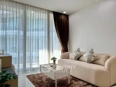 Elegant living room with plush sofa and floor-to-ceiling windows