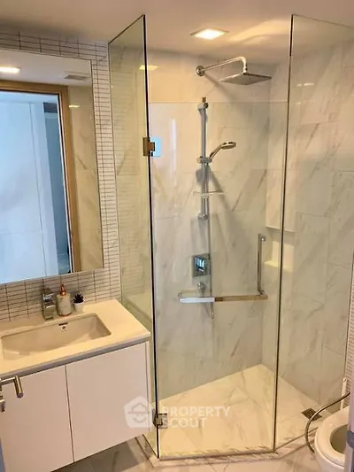 Modern bathroom with glass shower enclosure and sleek vanity