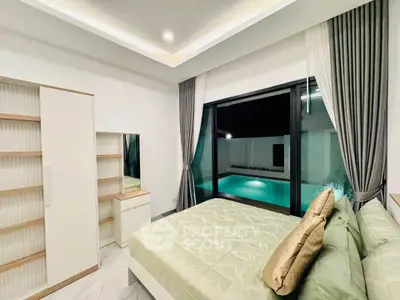 Luxurious bedroom with pool view, elegant decor, and modern furnishings.