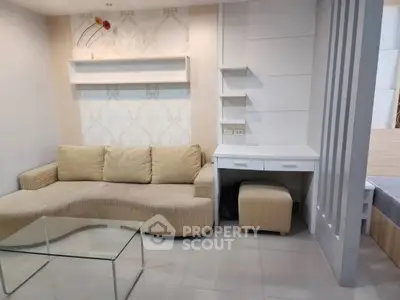 Modern living room with beige sofa and glass coffee table in stylish apartment