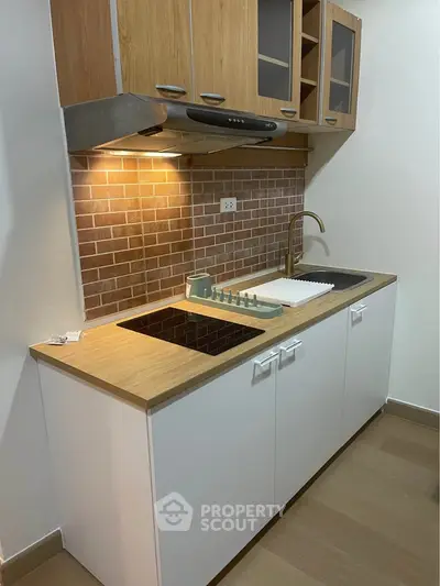 Modern kitchen with wooden cabinets and stylish backsplash in compact layout.