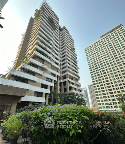 Stunning high-rise building with lush greenery and modern architecture in urban setting.