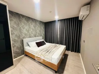 Modern bedroom with stylish wallpaper and cozy bed in contemporary apartment.