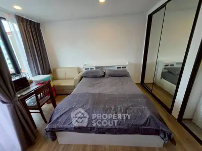 Modern bedroom with cozy bed, mirrored closet, and study area in a stylish apartment.