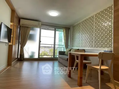 Modern living room with balcony, stylish decor, and natural light