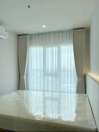 Bright bedroom with large window and city view, featuring modern curtains and air conditioning.