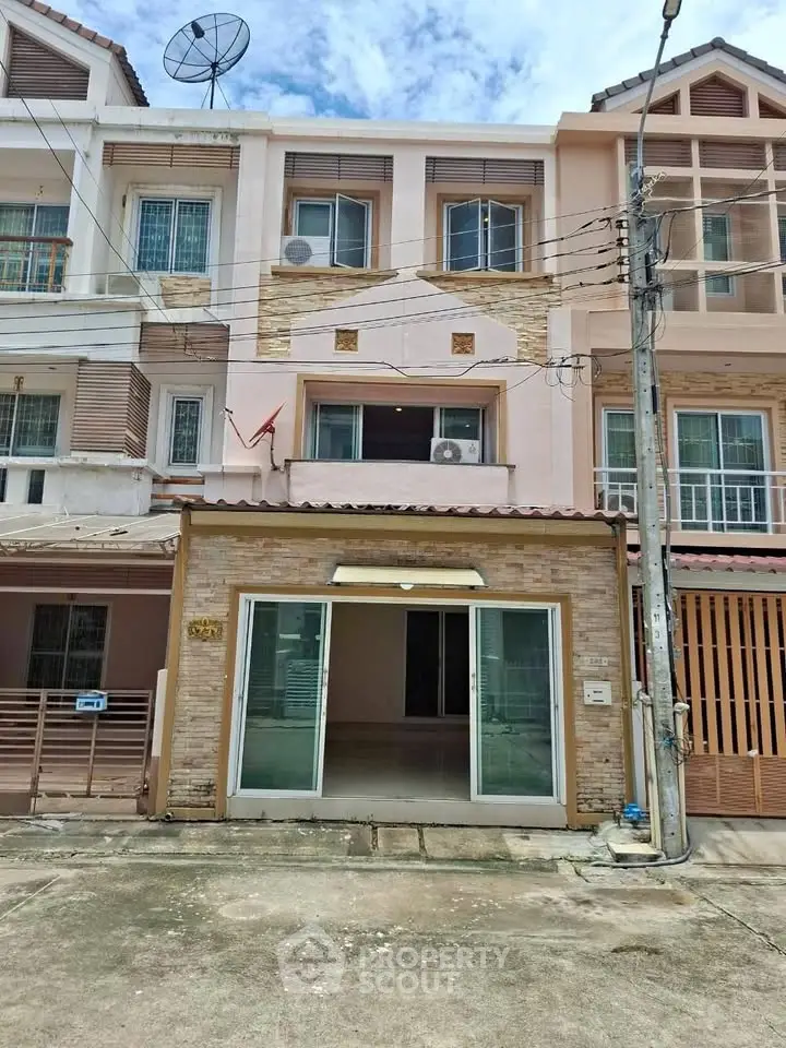 Charming townhouse exterior with modern facade and satellite dish, perfect for urban living.
