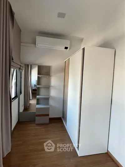 Spacious bedroom with modern wardrobe and air conditioning unit