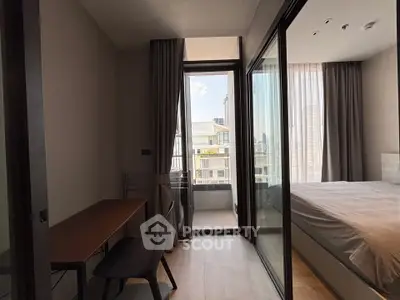 Modern bedroom with balcony access and study area, featuring sleek design and natural light.