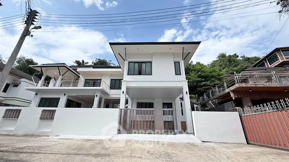 Modern two-story house with sleek design and spacious balcony in a serene neighborhood.