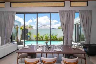 Luxurious dining area with pool view in modern villa, featuring elegant table setting and floor-to-ceiling windows.