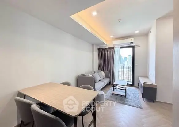 Modern living room with city view, featuring sleek furniture and natural light.