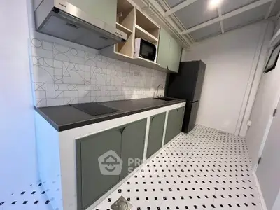 Modern kitchen with sleek cabinetry and stylish backsplash in a contemporary apartment.
