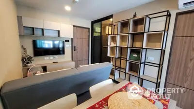 Modern living room with stylish shelving and wall-mounted TV in cozy apartment.