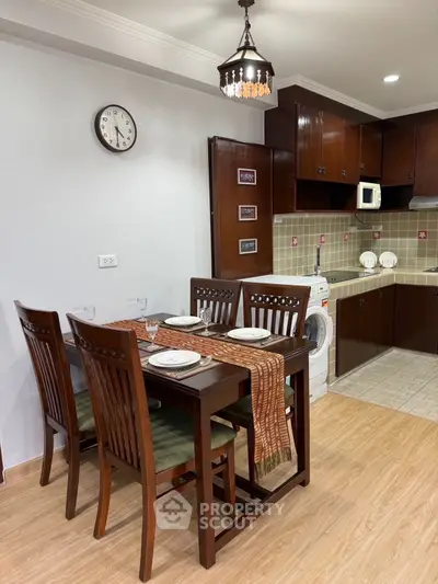 Charming dining area with wooden furniture and adjacent kitchen featuring modern appliances.