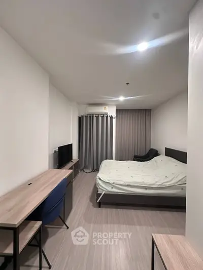 Modern bedroom with sleek furniture and ambient lighting in a contemporary apartment.