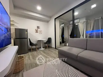 Modern living room with sleek furniture and open layout, featuring a cozy dining area and large windows.