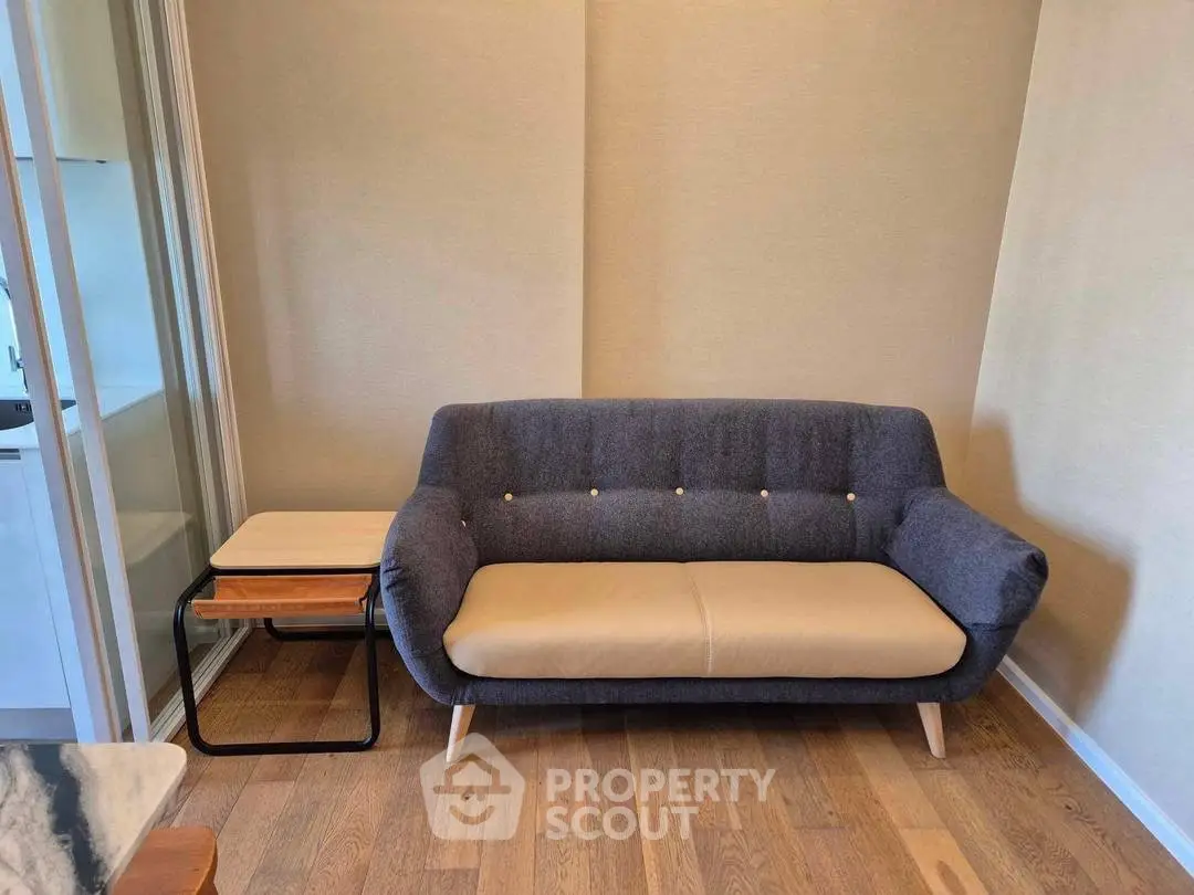 Modern living room with stylish sofa and wooden flooring, perfect for cozy urban living.