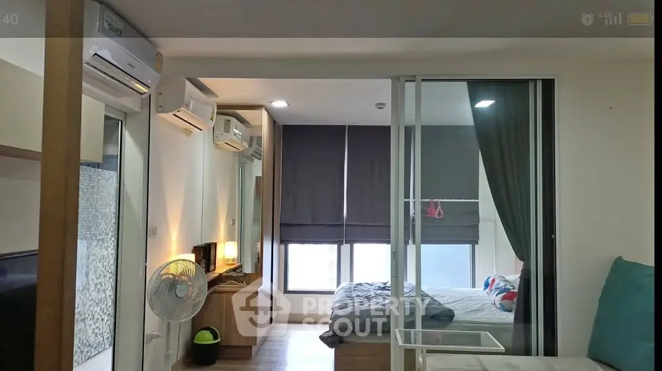 Modern bedroom with sliding glass doors and air conditioning in a stylish apartment.