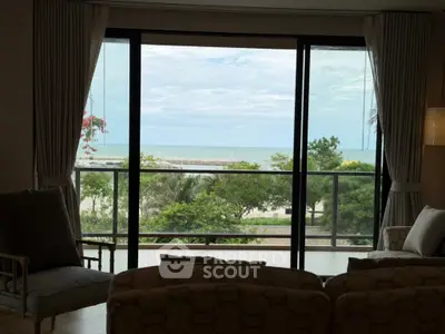 Stunning living room with panoramic ocean view through large glass doors.