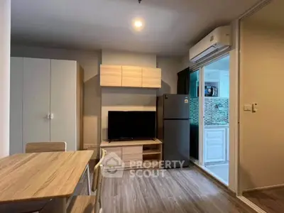 Modern living room with sleek furniture and kitchen view in a stylish apartment.