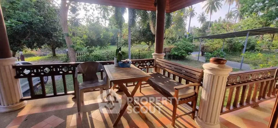 Charming outdoor patio with wooden furniture and lush garden view, perfect for relaxation and entertaining.