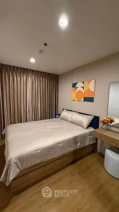 Cozy bedroom with modern decor and wooden flooring, featuring a comfortable bed and stylish artwork.