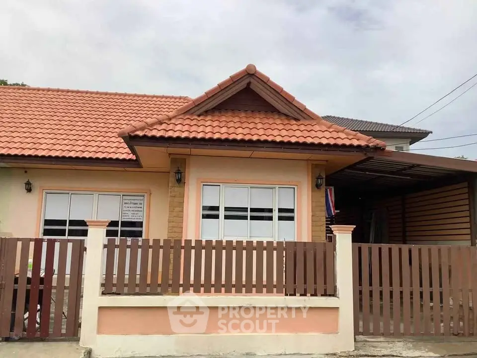 Charming single-story house with tiled roof and fenced yard, perfect for family living.