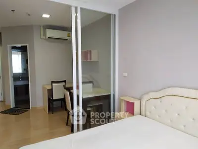 Modern bedroom with glass partition and study area, featuring elegant furnishings and ample natural light.