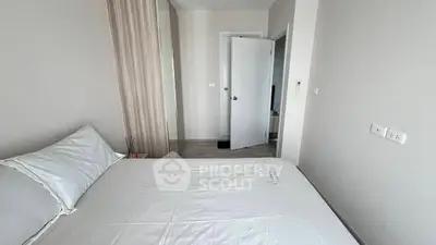 Cozy bedroom with modern decor and neutral tones, featuring a comfortable bed and sleek design.