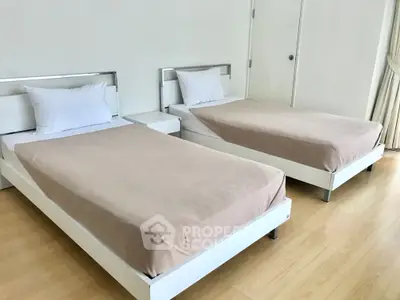 Spacious bedroom with twin beds and minimalist decor, perfect for a modern lifestyle.