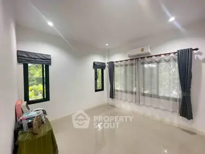 Spacious unfurnished room with large windows and air conditioning, ideal for customization.