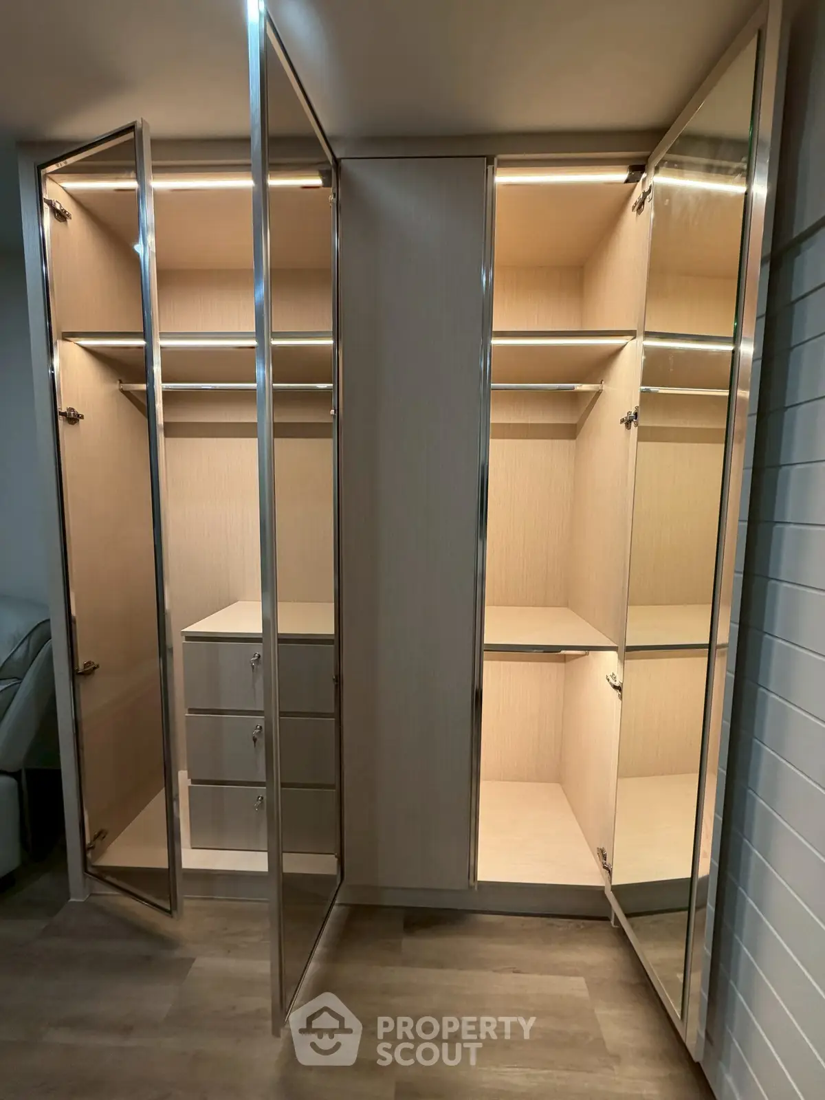 Spacious walk-in closet with elegant glass doors and ample shelving in modern home.