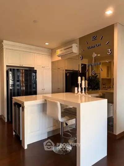 Luxurious modern kitchen with sleek white cabinetry and stylish bar seating