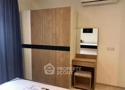 Modern bedroom with sleek wardrobe and vanity, featuring air conditioning for comfort.