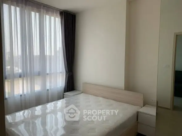 Bright and airy bedroom with large window and modern furnishings