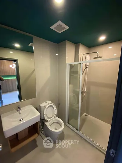 Modern bathroom with sleek shower enclosure and stylish fixtures in contemporary apartment.